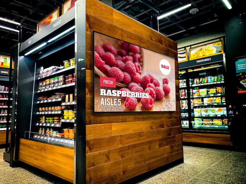 Digital sign on refrigerator case in grocery